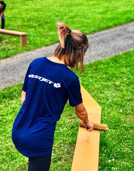 Westjey employee painting railing